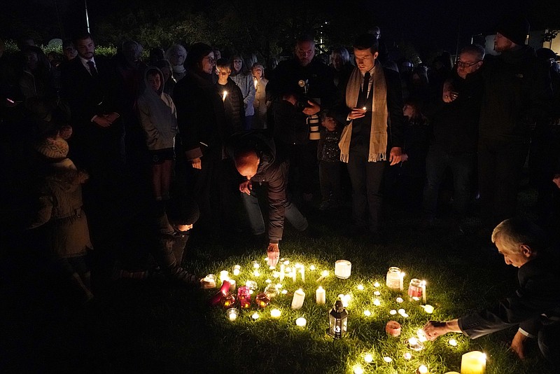 People light candles at a vigil in Leigh-on-Sea, Essex, England, Saturday, Oct. 16, 2021 to honor British Conservative lawmaker David Amess who died after being stabbed at a constituency surgery on Friday. Leaders from across the political spectrum came together Saturday to pay their respects to Amess who was stabbed to death in what police say was a terrorist-related attack. (AP Photo/Alberto Pezzali)