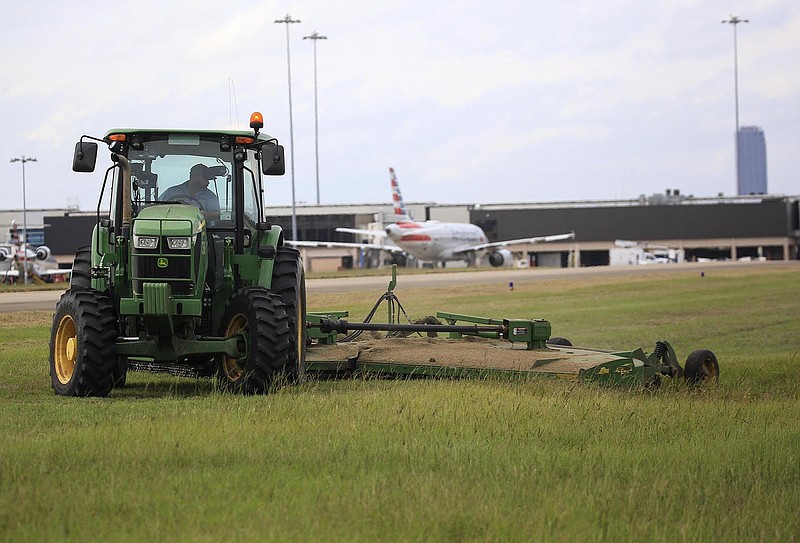 Equipment operator Buddy Hawley, (cq) works mowing grass near a taxiway with a tractor and bush hog Thursday Oct. 14, 2021 at Bill and Hillary Clinton National Airport in Little Rock. (Arkansas Democrat-Gazette/Staton Breidenthal)