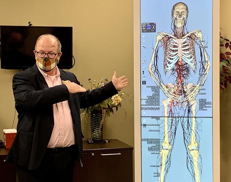 Mark Wallenmeyer, Northwest Arkansas Community College dean of health professions, provides a demonstration of an anatomy table the college will use to educate medical students Monday prior to a Board of Trustees meeting.