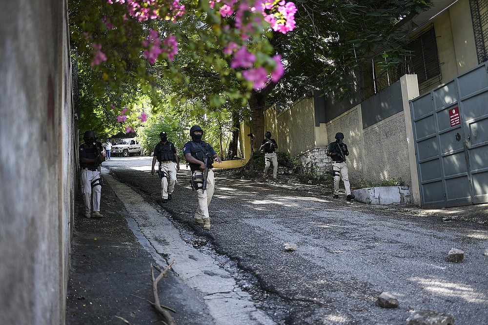 Police patrol the perimeter of the home of acting Prime Minister Ariel Henry as motorcyclists unable to find gas for sale at a fuel station arrive to protest in Port-au-Prince, Haiti, Tuesday, Oct. 19, 2021, on the day of a strike against rising violence. (AP Photo/Matias Delacroix)