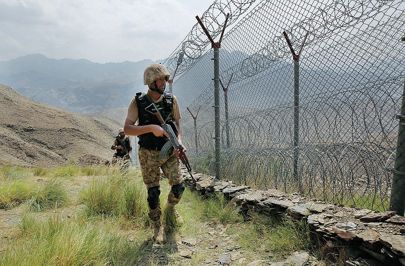 FILE - In this Aug. 3, 2021 file photo, Pakistan Army troops patrol along the fence on the Pakistan Afghanistan border at Big Ben hilltop post in Khyber district, Pakistan. The Taliban win in Afghanistan is giving a boost to militants in neighboring Pakistan. The Pakistani Taliban, known as the TTP, have become emboldened in tribal areas along the border with Afghanistan. (AP Photo/Anjum Naveed, File)