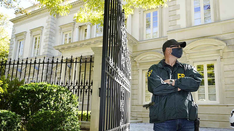 A federal agent stands in front of a home of Russian oligarch Oleg Deripaska, Tuesday, Oct. 19, 2021 in Washington. An agency spokesperson says FBI agents were at a home in Washington connected to Deripaska to carry out "court-authorized law enforcement activity." (AP Photo/Manuel Balce Ceneta)