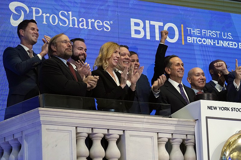 ProShares CEO Michael Sapir, second right, and company Global Investment Strategist Simeon Hyman, right, lead the New York Stock Exchange opening bell celebration, Tuesday, Oct. 19, 2021. ProShares will launch the country's first exchange-traded fund linked to Bitcoin. (AP Photo/Richard Drew)