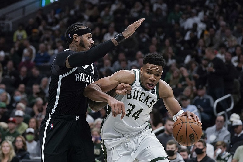 Milwaukee Bucks' Giannis Antetokounmpo (34) is defended by Brooklyn Nets' James Johnson during the first half of an NBA basketball game Tuesday, Oct. 19, 2021, in Milwaukee. (AP Photo/Morry Gash)
