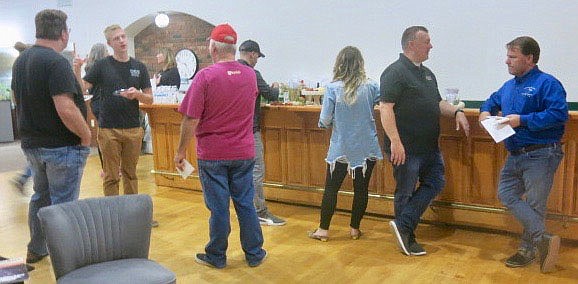 Westside Eagle Observer/SUSAN HOLLAND
Kurt Maddox (right), mayor of the City of Gravette, visits with J.W. Smith, an owner of Smith and Betts Barbecue, at the Greater Gravette Chamber of Commerce open house Wednesday afternoon, Oct. 20, while other area business owners enjoy visiting and refreshments. The open house was held in the chamber's new office on Main Street in observance of Support Your Local Chamber Day.