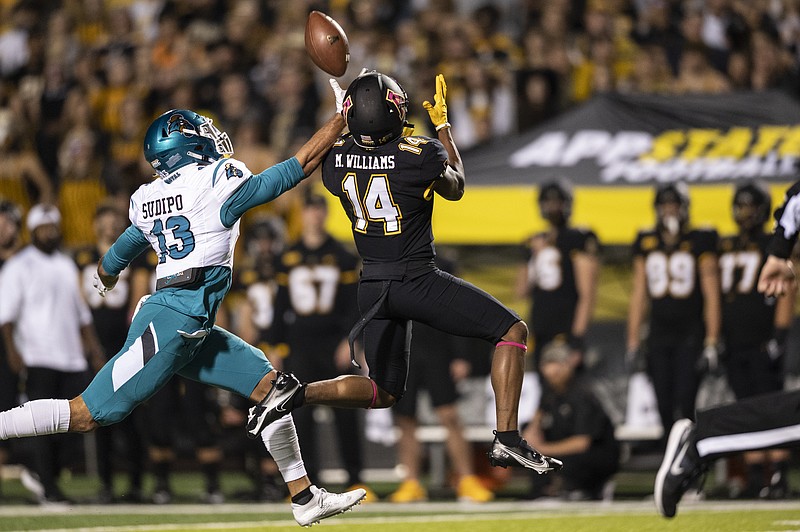 Coastal Carolina safety Mateo Sudipo (13) deflects a pass intended for Appalachian State wide receiver Malik Williams (14) during the first half of an NCAA college football game Wednesday, Oct. 20, 2021, in Boone, N.C. (AP Photo/Matt Kelley).