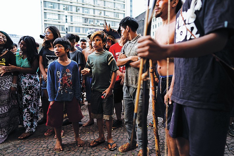 FILE - In this March 27, 2018, file photo, Indigenous people stand outside Sao Paulo's City Hall during a demonstration. On Friday, Oct. 22, The Associated Press reported on stories circulating online incorrectly asserting that a video showed aboriginal people in Australia defending themselves with bows and arrows against authorities trying to forcibly administer COVID-19 vaccines. In fact, the video showed a group of Guarani Indigenous people in Sao Paulo, Brazil, demonstrating against health care policy changes in March 2019. (AP Photo/Victor R. Caivano)