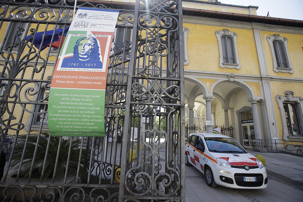 File - In questa foto di file del 14 aprile 2020, un'auto esce dalla struttura Pio Albergo Trivolgio Eldercare a Milano, Italia.  In una dichiarazione, venerdì 22 ottobre 2021, Amnesty International ha chiesto un'inchiesta parlamentare indipendente sulle denunce di decessi per COVID-19 nelle case di cura italiane e ritorsioni da parte del personale delle case di cura per aver parlato delle condizioni non sicure lì.  (Foto AB / Luca Bruno, file)