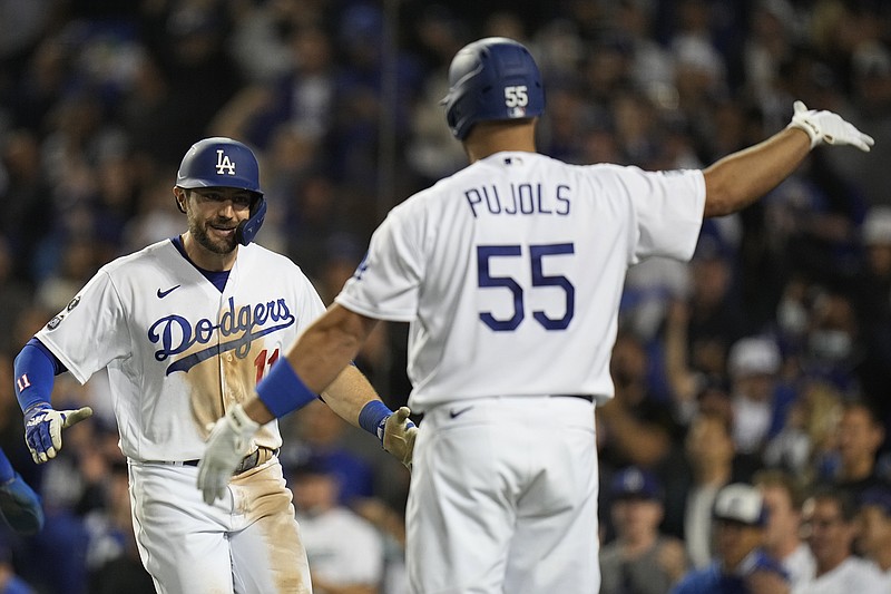 Los Angeles Dodgers' AJ Pollock is congratulated by Albert Pujols after hitting a three-run home run during the eighth inning against the Atlanta Braves in Game 5 of baseball's National League Championship Series Thursday, Oct. 21, 2021, in Los Angeles. (AP Photo/Jae C. Hong)