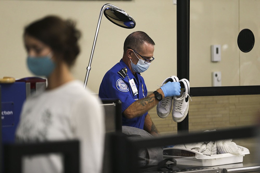 Mark Biancardi, transportation security officer, sorts personal items into bins as they go through security, Friday, October 22, 2021 at the Bentonville National Airport in Bentonville. Incidents of people bringing guns to airport security checkpoints are up across the country and Northwest Arkansas National Airport has had 24 such incidents so far this year, according to airport officials. Check out nwaonline.com/211023Daily/ for today's photo gallery.
(NWA Democrat-Gazette/Charlie Kaijo)