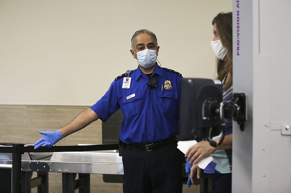 Gilbert Pineira, transportation security officer, allows an attendee past a security scanner, Friday, October 22, 2021 at the Bentonville National Airport in Bentonville. Incidents of people bringing guns to airport security checkpoints are up across the country and Northwest Arkansas National Airport has had 24 such incidents so far this year, according to airport officials. Check out nwaonline.com/211023Daily/ for today's photo gallery.
(NWA Democrat-Gazette/Charlie Kaijo)