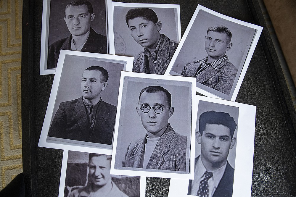 Copies of photos of Holocaust survivors are laid out during a reunion for their families in East Brunswick, N.J., on Sunday, Sept. 26, 2021. Anna Salton Eisen found the old pictures of Jewish prisoners who survived the Holocaust in a folder her late father, George Lucius Salton, kept most of his life. (AP Photo/Brittainy Newman)