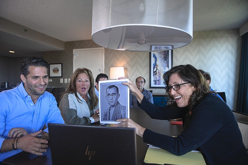 Anna Salton Eisen holds up a photo of Emil Ringel, father of Barbara Ringel, for a Zoom video call during a gathering for families of Holocaust survivors in East Brunswick, N.J., on Sunday, Sept. 26, 2021. Seventy-six years after American soldiers cut down the barbed wire and fulfilled the prisoners&#x2019; impossible dream of freedom, Eisen brought together survivors&#x2019; loved ones. (AP Photo/Brittainy Newman)