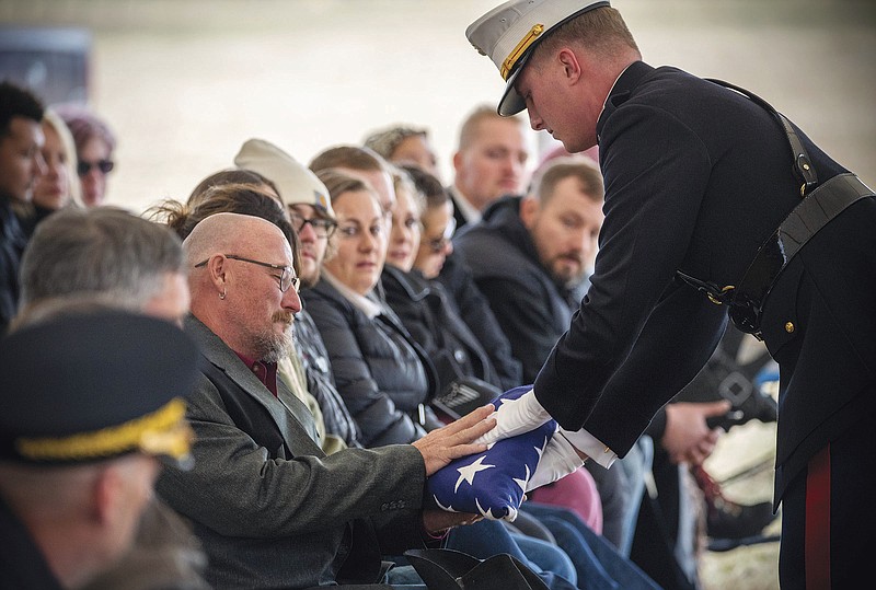 A U.S. Marine with the Golf Company, 1st Marines presents Jim McCollum with a folded American flag during memorial services for his son, Lance Cpl. Rylee McCollum, on Saturday, Oct. 23, 2021, at the Gill Ranch in Jackson, Wyo. McCollum was among 13 U.S. soldiers killed in a suicide bombing Aug. 26 at the Kabul airport. (Bradly J. Boner/Jackson Hole News & Guide via AP)