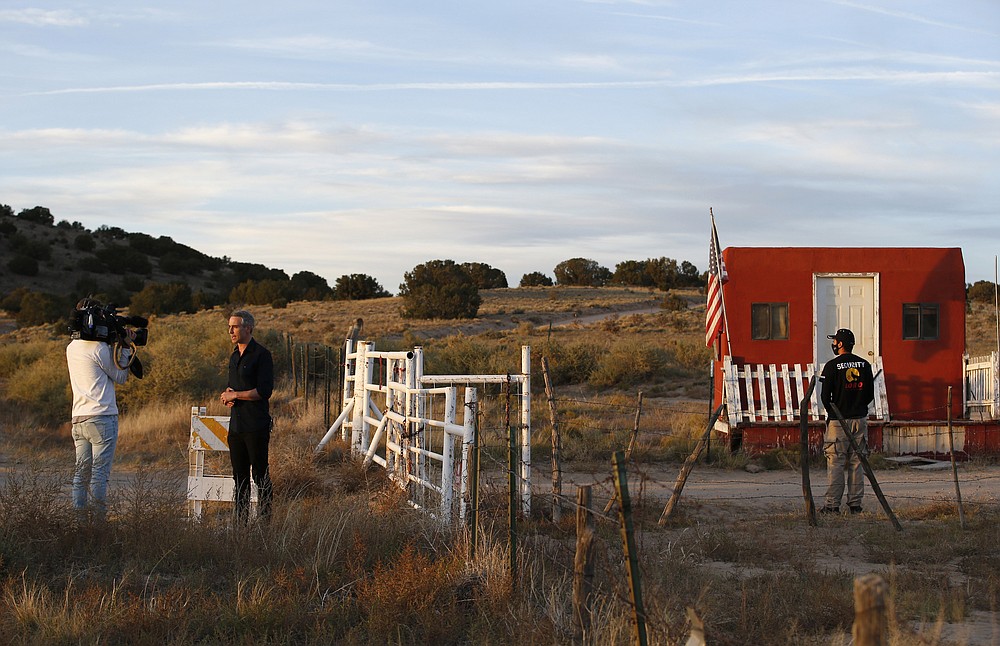 A TV news crew tapes a report at the entrance of the Bonanza Creek Film Ranch in Santa Fe, N.M. Friday, Oct. 22, 2021. Actor Alec Baldwin fired a prop gun on the set of a Western being filmed at the ranch on Thursday, Oct. 21, killing the cinematographer, officials said. The director of the movie was wounded, and authorities were investigating. (AP Photo/Andres Leighton)