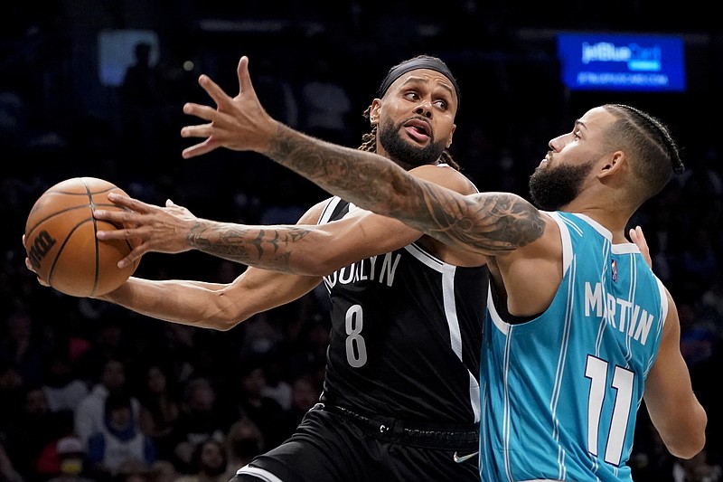 Brooklyn Nets guard Patty Mills (8) looks to pass against Charlotte Hornets forward Cody Martin (11) during the second half of an NBA basketball game, Sunday, Oct. 24, 2021, in New York. (AP Photo/John Minchillo)