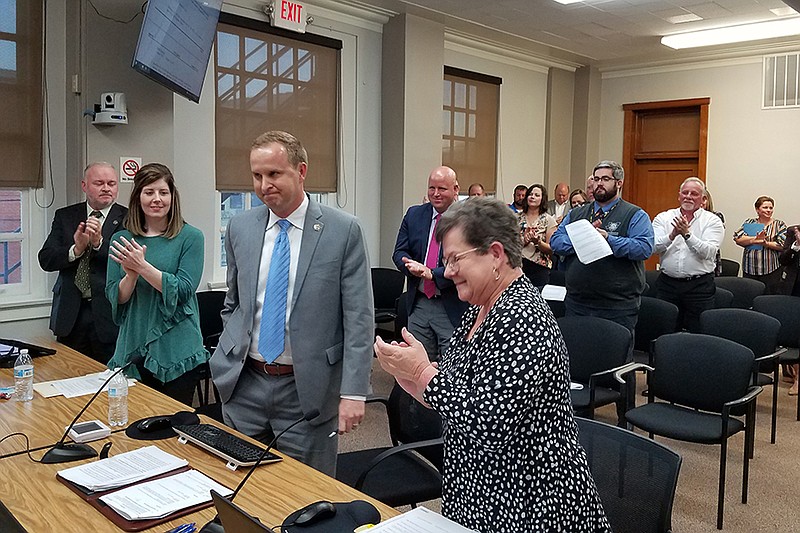 David Orr, third from left, receives a standing ovation from city staffers and the audience after the City Council voted unanimously to name him city manager during a regular meeting Monday at City Hall in Texarkana, Texas. Orr had held the position on an interim basis since former City Manager Shirley Jaster retired in the spring. (Staff photo by Karl Richter)