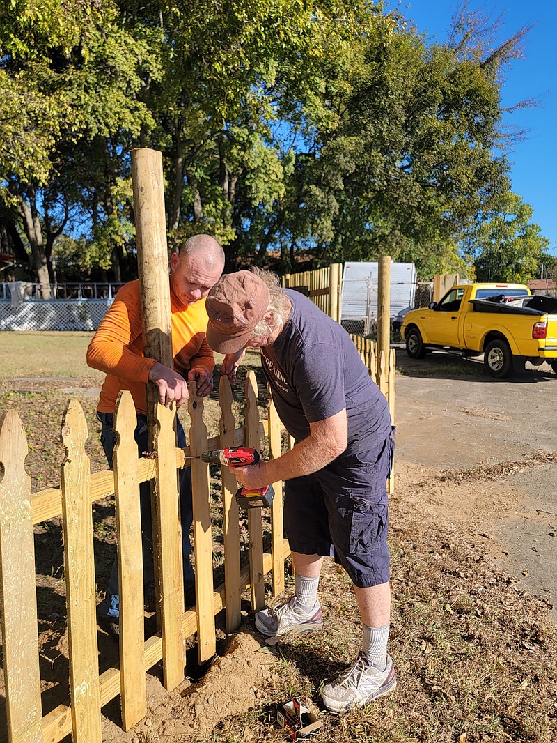 James Beck, left, holds fencing in place while Ronald Hansen, right, drills it into a pole to hold it into place on Monday morning. Hansen’s back property line faces Broad Street between its intersection with Senator and Linden streets. Hansen said he was inspired to put up fencing to spruce things up because of all the improvements in downtown Texarkana Arkansas. (Photo by Christy Busby Worsham)