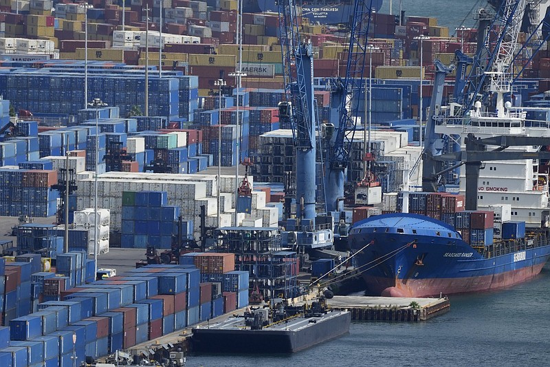 Cranes unload containers from the Seaboard Ranger cargo ship, Wednesday, Oct. 20, 2021, at PortMiami in Miami. The Federal Reserve reports that the economy faced a number of headwinds at the start of this month, ranging from supply-chain disruptions and labor shortages to uncertainty about the delta variant of COVID.(AP Photo/Rebecca Blackwell)