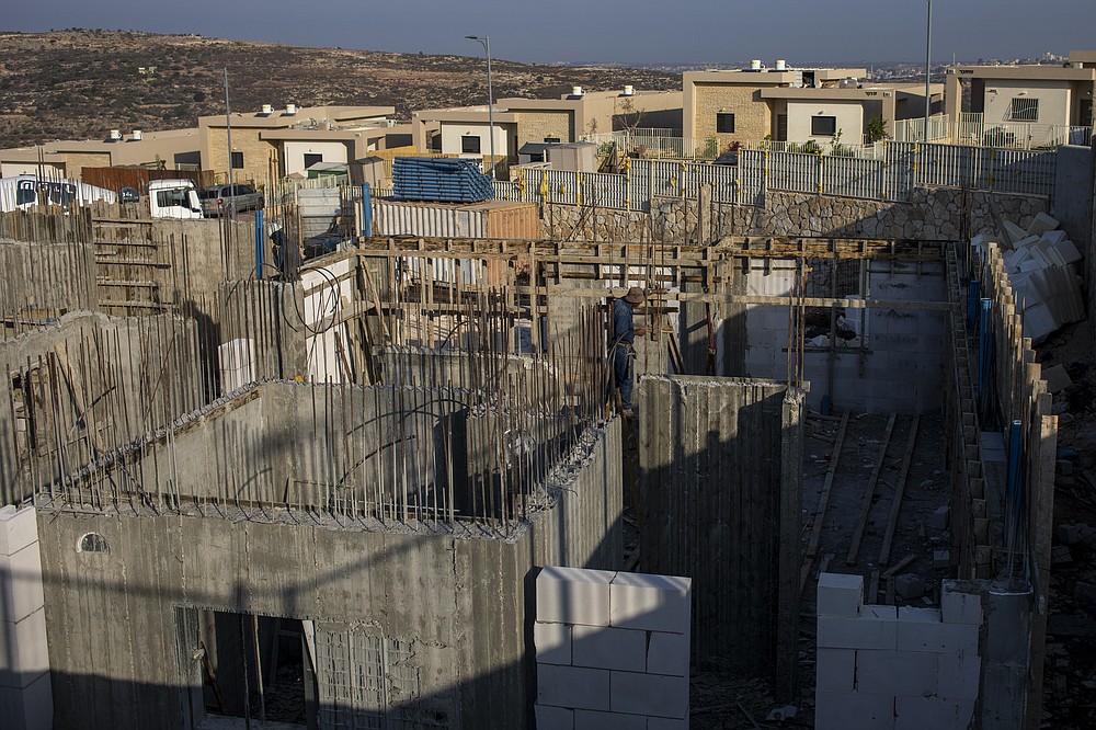 Palestinians built new houses in the West Bank Jewish settlement of Bruchin near the Palestinian town of Nablus, Monday, Oct. 25, 2021. Israel is expected to move forward with thousands of new homes for Jewish settlers in the West Bank this week, a settlement watchdog group said Sunday. (AP Photo/Ariel Schalit)