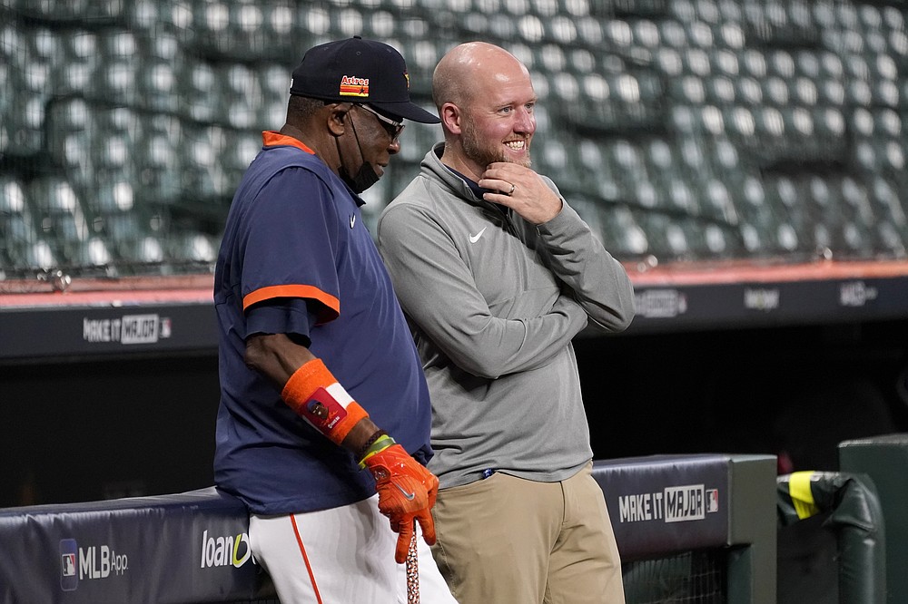 Houston Astros manager Dusty Baker, left, smiles as he talks with general manager James Click, right, during baseball practice in Houston, Thursday, Oct. 14, 2021. The Astros host the Boston Red Sox in Game 1 of the American League Championship Series on Friday. (AP Photo/Tony Gutierrez)