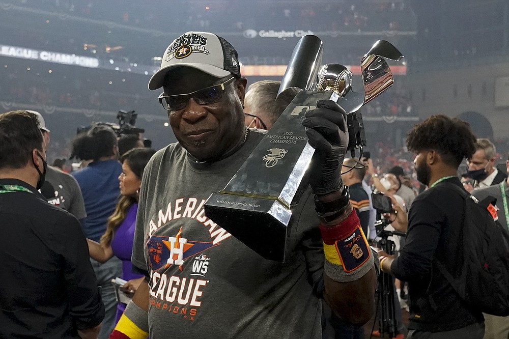 Houston Astros manager Dusty Baker Jr. holds the trophy after their win against the Boston Red Sox in Game 6 of baseball's American League Championship Series Friday, Oct. 22, 2021, in Houston. The Astros won 5-0, to win the ALCS series in game six. (AP Photo/Tony Gutierrez)