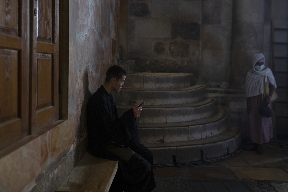 FILE - In this April 30, 2021, file photo, an altar boy checks his mobile phone in the Old City of Jerusalem. From complaints whistleblower Frances Haugen has filed with the SEC, along with redacted internal documents obtained by The Associated Press, the picture of the mighty Facebook that emerges is of a troubled, internally conflicted company, where data on the harms it causes is abundant, but solutions are halting at best. (AP Photo/Maya Alleruzzo, File)
