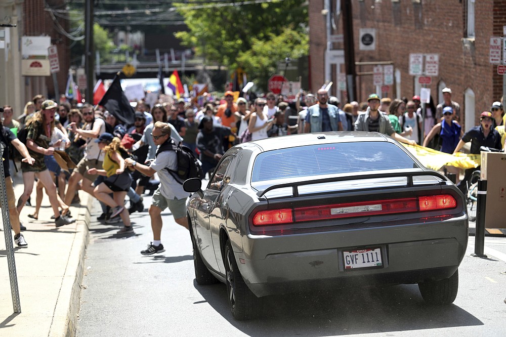 FILE - In this Aug. 12, 2017, file photo, a vehicle drives into a group of protesters demonstrating against a white nationalist rally in Charlottesville, Va. A trial is beginning in Charlottesville, Virginia to determine whether white nationalists who planned the so-called &#x201c;Unite the Right&#x201d; rally will be held civilly responsible for the violence that erupted. (Ryan M. Kelly/The Daily Progress via AP, File)