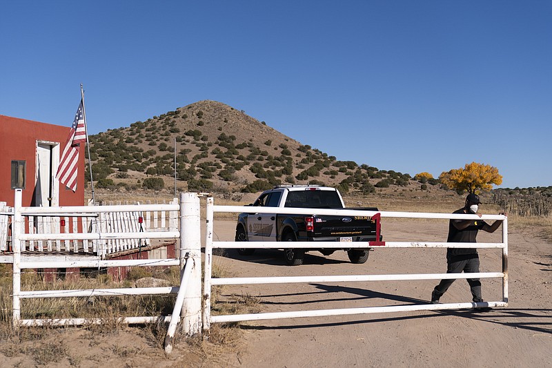 A security guard closes the gate after a Santa Fe County Sheriff's vehicle entered the Bonanza Creek Ranch in Santa Fe, N.M., Monday, Oct. 25, 2021. Production of the movie that Alec Baldwin was making when he shot and killed a cinematographer last week has been officially halted, but producers of the Western described the move as &quot;a pause rather than an end.&quot; (AP Photo/Jae C. Hong)
