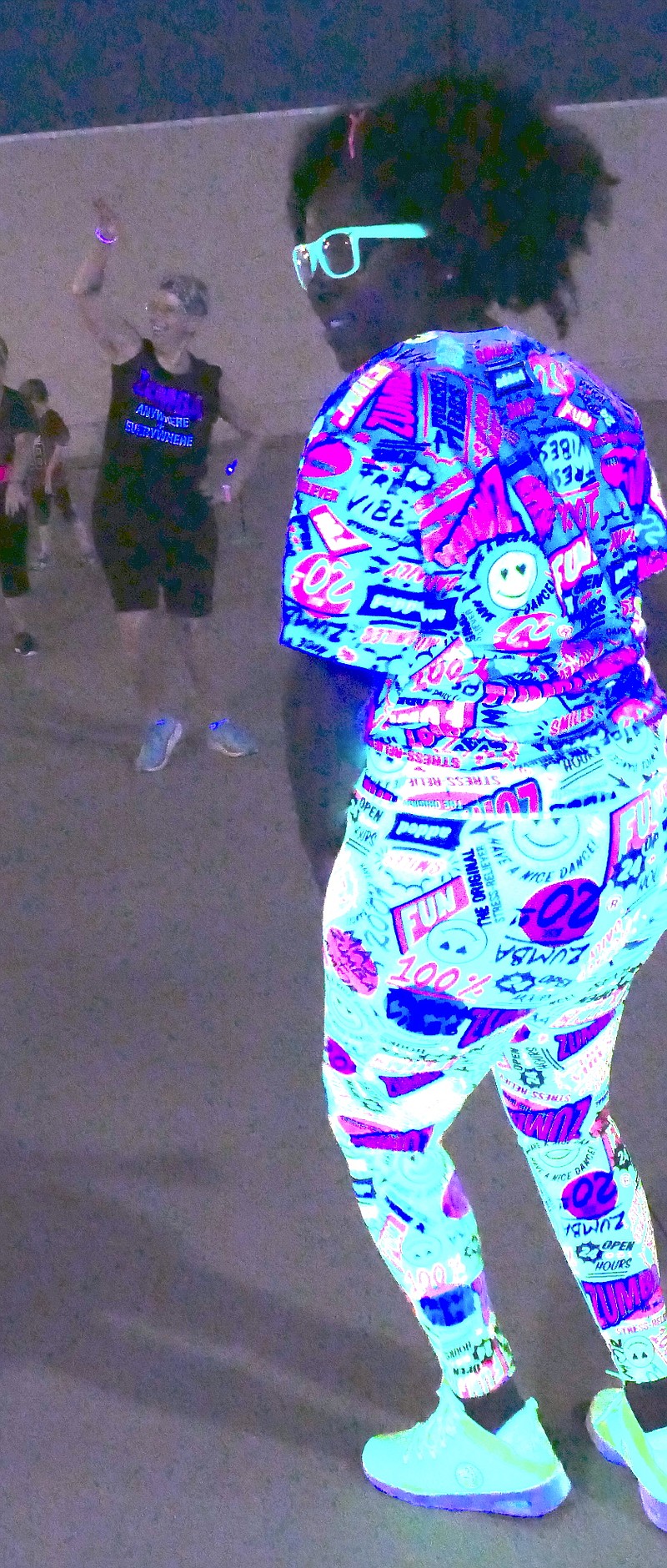 Betty Coleman is surely standing out as she leads the black light Zumba dancing for the Glow Run in Atlanta, Texas. This is because she’s near a black light lamp. Certain fabrics reflect the black light. Staff photo by Neil Abeles