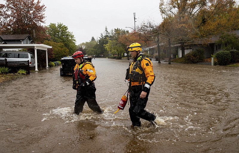 Santa Rosa firefighters check for residents trapped by floodwaters on Neotomas Avenue in Santa Rosa, Calif., on Sunday, Oct. 24, 2021. (AP Photo/Ethan Swope)