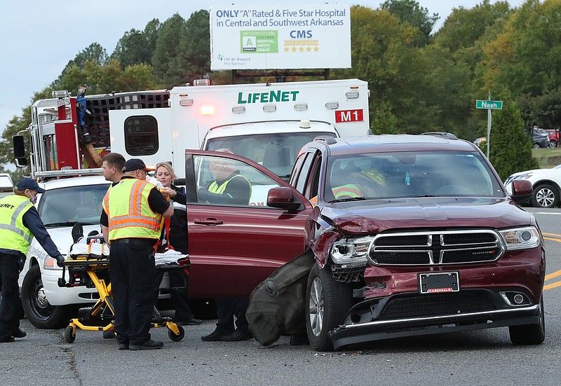 Emergency personnel work the scene of a two-vehicle wreck that occurred around 9:15 a.m. Tuesday by the westbound on ramp to the King Expressway near the intersection of Werner and Nash streets. - Photo by Richard Rasmussen of The Sentinel-Record
