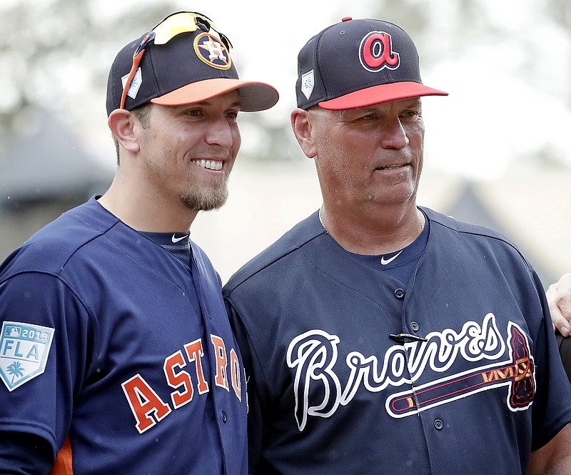 FILE- Houston Astros hitting coach Troy Snitker, left, stands with his father Braves manager Brian Snitker before a spring baseball exhibition game, Monday, March 4, 2019, in Kissimmee, Fla. No matter how this year’s World Series ends, a Snitker will get a championship ring.  This edition of the Fall Classic is a family affair with Atlanta Braves manager Brian Snitker in the dugout opposite his son, Houston Astros co-hitting coach Troy Snitker. (AP Photo/John Raoux, File)