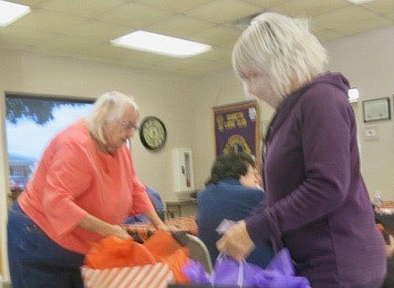 Westside Eagle Observer/SUSAN HOLLAND
Sandy Steinhaus (left) and Carole Robel investigate the contents of their gift bags after winning prizes in a Halloween scratch-off card contest at the Billy V. Hall Senior Activity Center. Each patron was given a card and persons scratching off a pumpkin symbol won nice prizes including a soft, warm throw. &quot;Boo&quot; cards were not winners.