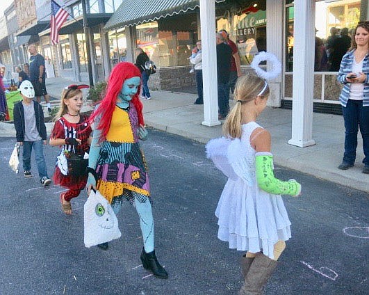 Westside Eagle Observer/SUSAN HOLLAND
A line of costumed youngsters follows the numbers as they listen to Halloween music at the Jolly Good Times Extension Club's cake walk. Extension Club members offered delicious home-baked cupcakes, cookies and brownies as prizes for those who stopped on the correct numbers.