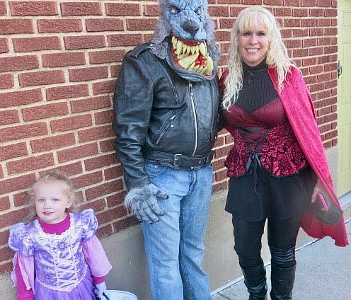 Westside Eagle Observer/SUSAN HOLLAND
Bryan and Teresa Berry, dressed as the big bad wolf and Red Riding Hood, pause from their rounds at Trick or Treat on Main Street to pose with their granddaughter. The Berrys came from Tallapoosa, Ga., to visit and trick or treat with the little princess.