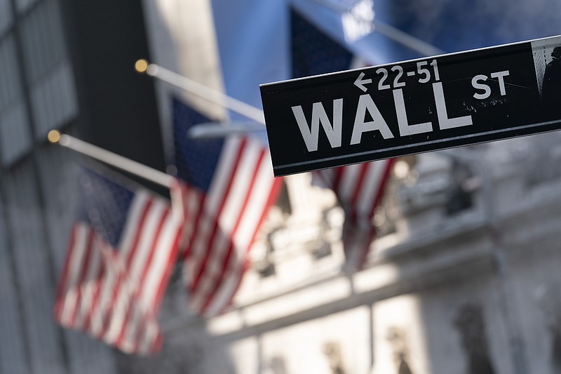 FILE - A sign for Wall Street hangs in front of the New York Stock Exchange, July 8, 2021. Stocks are off to a mixed start on Wall Street Wednesday, Oct. 27, 2021 a day after the S&amp;P 500 and the Dow Jones Industrial Average set their latest record highs. Several big technology companies were posting solid gains, led by Microsoft, which posted a 24% surge in profits last quarter as its cloud computing business bounded ahead. (AP Photo/Mark Lennihan, file)