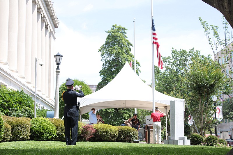 Members of the VFW Post 2413 and American Legion Post 10 stand at attention as El Dorado Police Officer Gerid Ardwin plays “Taps” during a Memorial Day ceremony at the Union County Courthouse on Monday, May 31, 2021. (News-Times file)