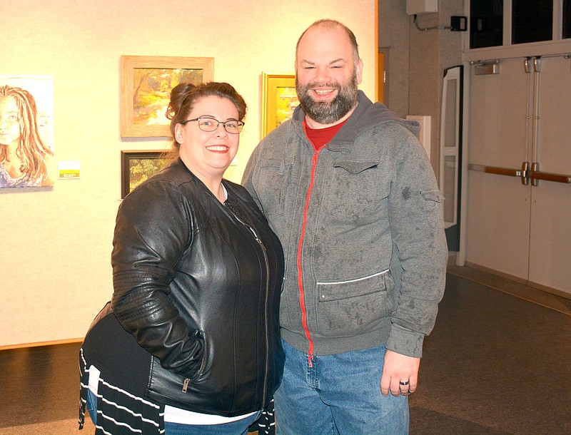 Marc Hayot/Siloam Sunday Attendees Jonathan and Lauren Abbott pose for a photo at the plein air art gallery opening on Thursday at the Wingate Gallery at John Brown University. The gallery will display the plein air paintings until Dec. 18.