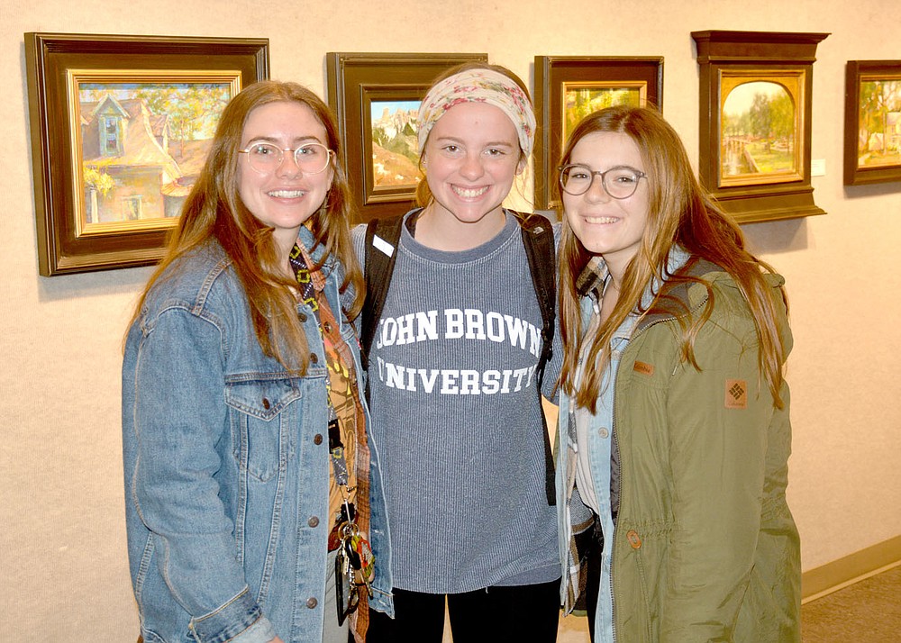 Marc Hayot / Siloam Sunday John Brown University Student Abby Lawler (center), poses with friends Hannah Williams (left) and Tessa Greathouse at the outdoor gallery opening Thursday at the Wingate Gallery at John Brown University .