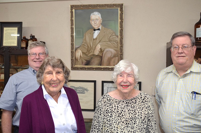 David Brown, Dallas County Museum founder Agnes Wynne Phillips, Pat Rhine Brown and Thomas Brown pose before a portrait of the Browns, father and grandfather, Dr. Thomas Edwin Rhine in the Dr. Rhine exhibit room of the museum. (Special to The Commercial/Richard Ledbetter)