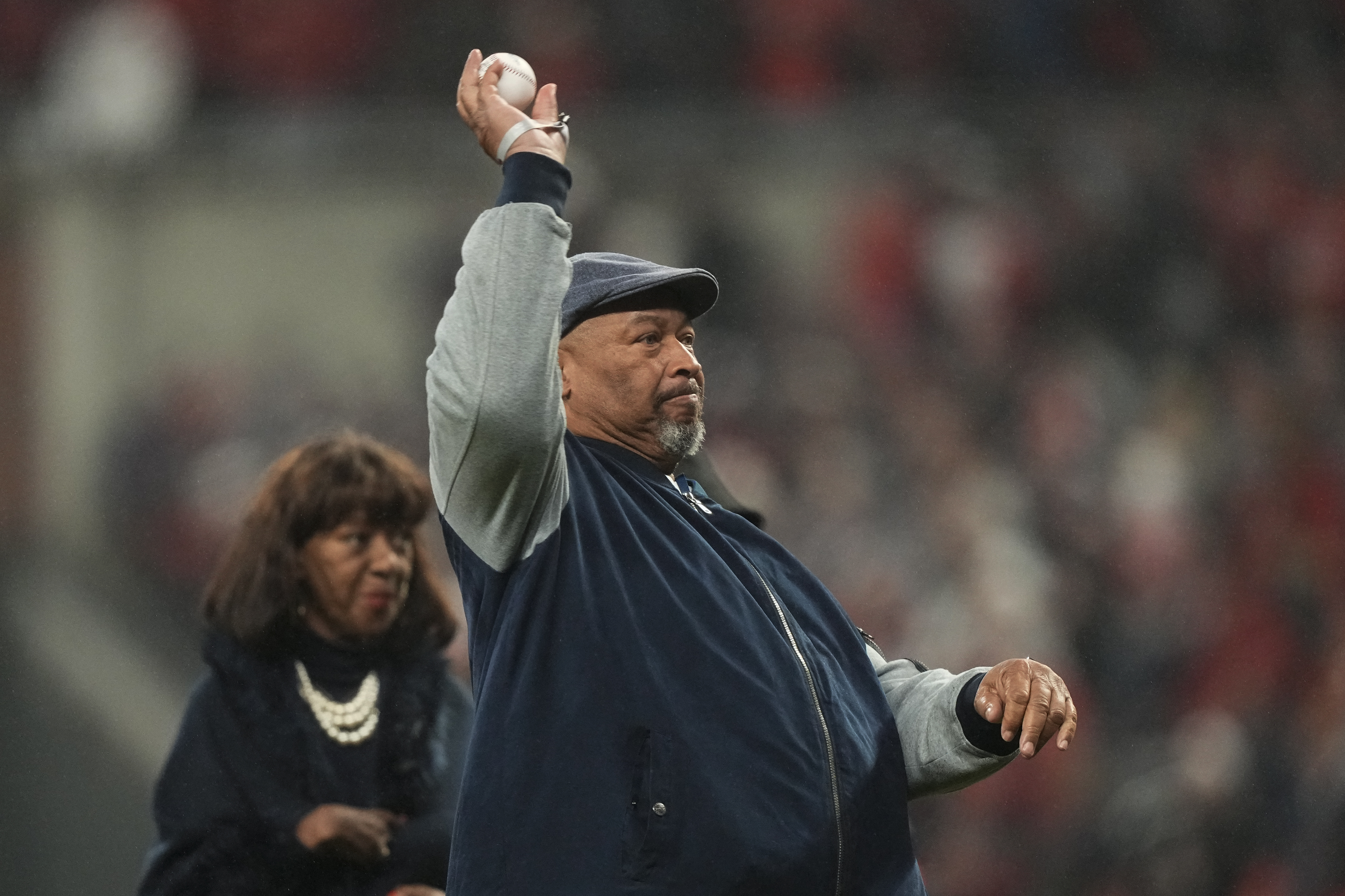 FILE - In this April 8, 1974, file photo, Hank Aaron tips his hat to fans  and teammates, including Dusty Baker (12, wearing batting helmet at center  right), greeting him at home