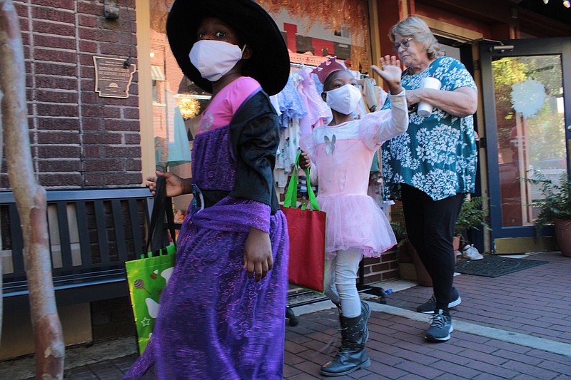 Aryanna, left, and Mathia Williams, a purple witch and a pink princess, respectively, said they liked trick-or-treating Saturday at Scare on the Square in downtown El Dorado. (Caitlan Butler/News-Times)
