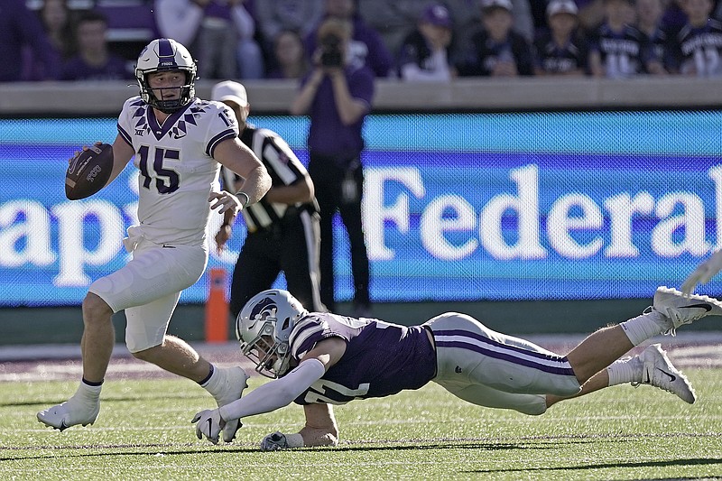 TCU quarterback Max Duggan (15) looks for a receiver under pressure from Kansas State defensive end Nate Matlack (97) during the first half of an NCAA college football game, Saturday, Oct. 30, 2021, in Manhattan, Kan. (AP Photo/Charlie Riedel)