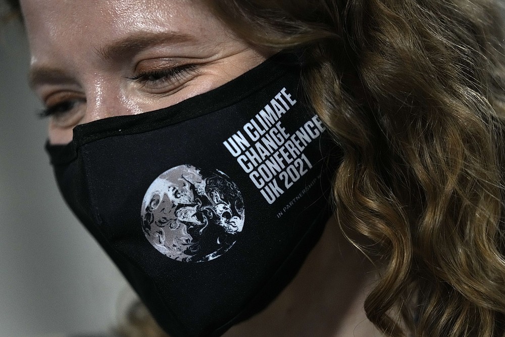 A delegate wears a face mask at the COP26 U.N. Climate Summit in Glasgow, Scotland, Sunday, Oct. 31, 2021. The U.N. climate summit in Glasgow formally opens Sunday, a day before leaders from around the world gather in Scotland's biggest city to lay out their vision for addressing the common challenge of global warming. (AP Photo/Alastair Grant)