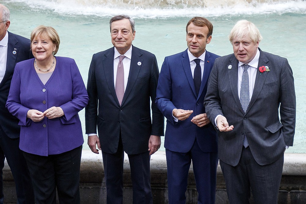From left, German Chancellor Angela Merkel, Italian Premier Mario Draghi, French President Emmanuel Macron and British Prime Minister Boris Johnson stand at the Trevi Fountain during an event for the G20 summit in Rome, Sunday, Oct. 31, 2021. The two-day Group of 20 summit concludes on Sunday, the first in-person gathering of leaders of the world's biggest economies since the COVID-19 pandemic started. (Roberto Monaldo/LaPresse via AP)