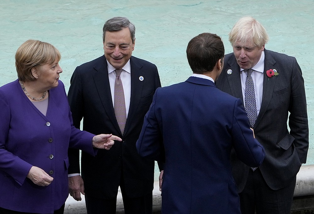 From left, German Chancellor Angela Merkel, Italy's Prime Minister Mario Draghi, French President Emmanuel Macron and British Prime Minister Boris Johnson speak in front of the Trevi Fountain during an event for the G20 summit in Rome, Sunday, Oct. 31, 2021. The two-day Group of 20 summit concludes on Sunday, the first in-person gathering of leaders of the world's biggest economies since the COVID-19 pandemic started. (AP Photo/Gregorio Borgia)