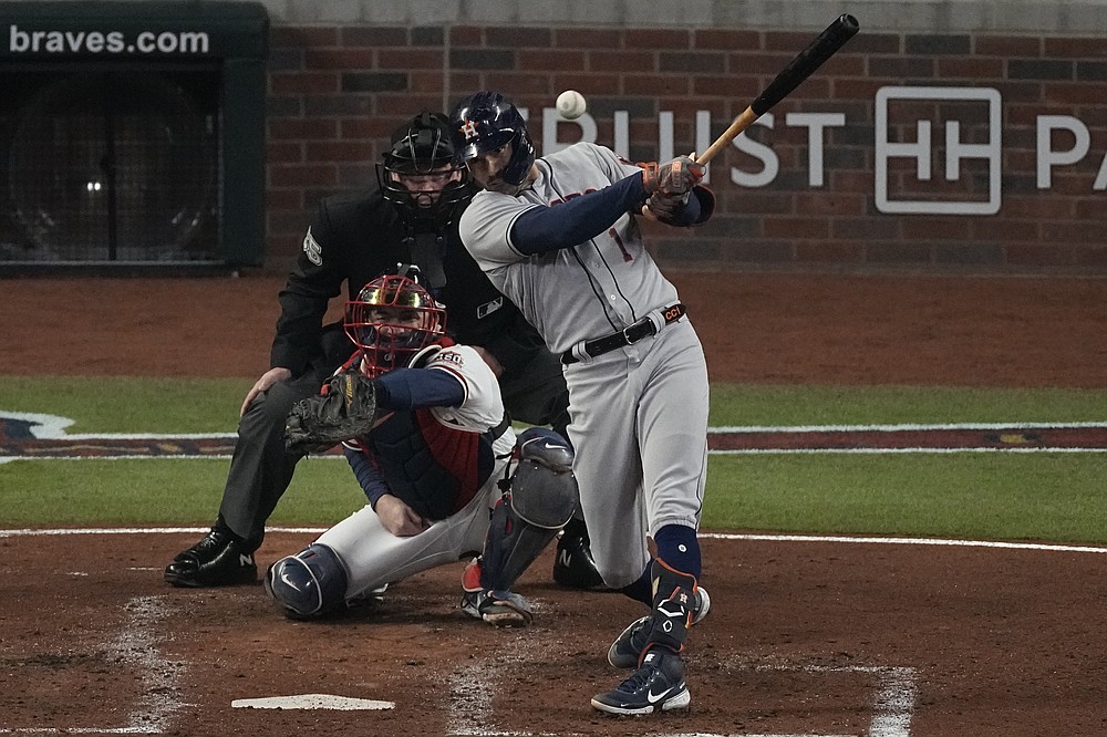 Houston Astros' Carlos Correa hits an RBI-double during the third inning in Game 5 of baseball's World Series between the Houston Astros and the Atlanta Braves Sunday, Oct. 31, 2021, in Atlanta. (AP Photo/John Bazemore)