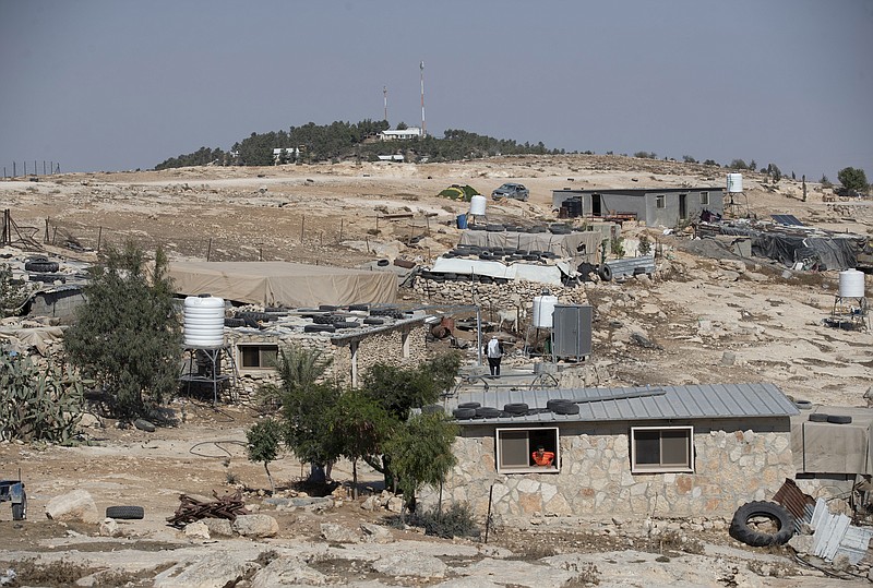 FILE - The Israeli settlement of Ma'on, in the background and overlooks the the West Bank Palestinian Bedouin village of al-Mufagara, near Hebron, Sept. 30, 2021. On Sunday, Nov. 1, 2021, Israel authorized some 1,300 Palestinian homes in the occupied West Bank days after advancing plans to build more than 3,000 housing units for Jewish settlers. The Israeli government said it is adopting a moderate approach with the aim of minimizing friction with the U.S. &#x2014; which is opposed to settlements &#x2014; and tensions within its ruling coalition, which includes parties from across the political spectrum. (AP Photo/Nasser Nasser, File)