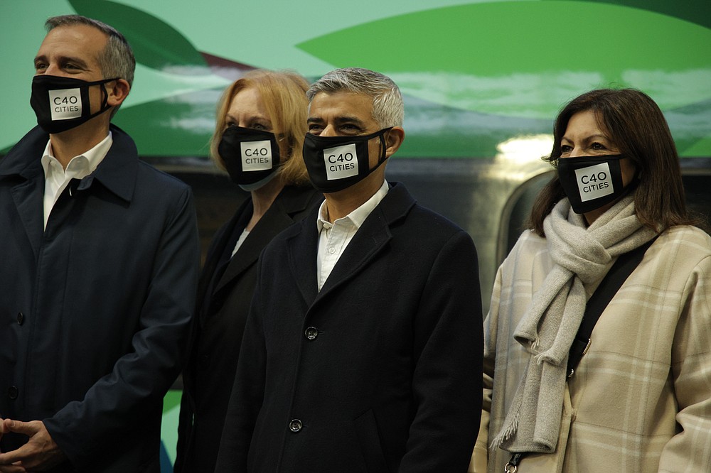 Mayor of London Sadiq Khan, centre, standing beside Mayor of Paris Anne Hidalgo, right, poses with a delegation of mayors also from the cities of Athens, Stockholm, North Dhaka, Phoenix, Los Angeles, Seattle, Freetown, Oslo, Rio de Janeiro and Barcelona beside a train taking them to the COP26 U.N. Climate Summit in Glasgow from Euston Station in London, Monday, Nov. 1, 2021. A formal opening of the summit yesterday kicked off two weeks of intense diplomatic negotiations by almost 200 countries aimed at slowing intensifying global warming and adapting to the climate damage already underway. (AP Photo/David Cliff)